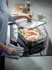 A person is cooking salmon and vegetables in a steamer pot on a stovetop. Náhľad obrázku produktu