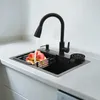A black kitchen sink with a faucet, a soap dispenser, a dish rack with apples, and a cup rinser. Podgląd zdjęcia produktu