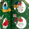 A close-up view of a miniature wooden Christmas tree with various ornaments hanging inside circular cutouts. Anteprima dell’immagine prodotto