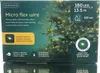 The image shows the packaging of Lumineo Micro flex wire string lights, with a Christmas tree decorated with the lights in the background. Produktbild-Vorschau