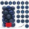 A collection of dark blue Christmas ornaments displayed in a clear plastic container and arranged around it. Podgląd zdjęcia produktu