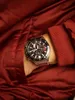 A close-up shot of a man's wrist wearing a Casio Edifice watch, partially tucked into the pocket of a red jacket. Voir les images du produit