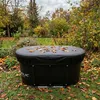 An outdoor scene in autumn with a covered round tub on grass, surrounded by fallen leaves and trees. Anteprima dell’immagine prodotto