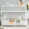 A white wooden house-shaped bed frame with a mattress, pillows, and stuffed animals. Produktbild-Vorschau