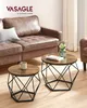 Two round coffee tables with a vintage brown top and black geometric bases are placed in front of a brown leather sofa. Podgląd zdjęcia produktu