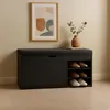 A black shoe cabinet with a cushioned seat and open shelves for shoes, displayed in a room with a framed picture on the wall and a vase with greenery on top. Náhľad obrázku produktu