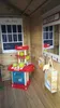 Interior of a wooden playhouse with a toy kitchen and a chalkboard. Produktbild-Vorschau