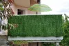 A balcony with a green privacy screen and a striped umbrella. Náhled obrázku produktu