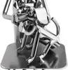 A close-up of a metal figurine of a dog, made from nuts and bolts, sitting on a metal surface. Náhľad obrázku produktu