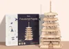 A 3D wooden pagoda model is displayed next to its packaging. Voir les images du produit