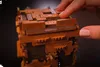 A close-up shot of a person's fingers interacting with a complex wooden puzzle box. Produktbild-Vorschau