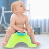 A baby sitting on a green potty in a nursery. Produktbild-Vorschau