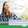 A woman in a greenhouse wearing safety glasses and a plaid shirt, tending to plants. A close-up of safety glasses is inset in the upper right corner. Podgląd zdjęcia produktu