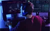 A person wearing headphones is playing a video game on a computer. Produktbild-Vorschau