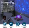 A baby is in a crib next to a glowing turtle night light projecting underwater effects and musical notes onto the wall. Podgląd zdjęcia produktu