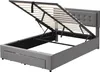 A grey upholstered bed frame with the mattress support mechanism lifted to reveal storage space underneath. Náhled obrázku produktu