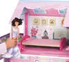 A doll is being placed into a large, pink, multi-story dollhouse. Náhľad obrázku produktu