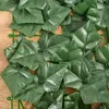 A close-up view of artificial dark green ivy leaves attached to a green plastic grid. Produktbild-Vorschau