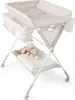 A baby changing table with storage and a stuffed animal. Produktbild-Vorschau
