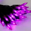 A close-up, angled view of a string of purple LED lights with black wires against a light gray and white background. Produktbild-Vorschau