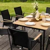 An outdoor dining set with chairs and a table on a wooden deck, with a grassy area in the background. Produktbild-Vorschau