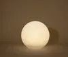 A glowing white sphere sits on a flat surface against a gradient brown background. Produktbild-Vorschau