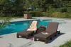 Two brown rattan-look sun loungers are placed on a patio next to a swimming pool. Náhled obrázku produktu