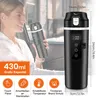 A woman is holding a black electric travel mug in a car. Produktbild-Vorschau