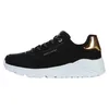 A side view of a black Skechers sneaker with white soles and gold accents. Voir les images du produit