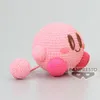 A crocheted pink Kirby plush toy is shown from the side against a light gray background. Produktbild-Vorschau