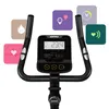 Close-up of the handlebars and console of a stationary exercise bike, with feature icons surrounding it. Produktbild-Vorschau
