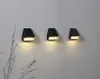 Three black LED solar wall lights mounted on a textured gray wall. Produktbild-Vorschau