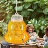 People enjoying drinks outdoors with a wasp trap hanging nearby. Produktbild-Vorschau