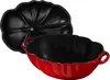 A red cast iron pot shaped like a tomato, with its black lid placed next to it. Náhľad obrázku produktu
