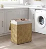 A laundry basket filled with clothes in a laundry room next to a washing machine. Náhľad obrázku produktu
