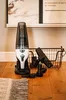 A cordless vacuum cleaner and its accessories are displayed on a wooden floor next to a rug. Anteprima dell’immagine prodotto