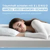 A woman is sleeping peacefully on a mattress with a pillow. Produktbild-Vorschau
