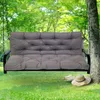 A gray swing bench with cushions is hanging from a tree in a grassy yard. Produktbild-Vorschau