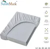 A light gray fitted sheet is shown on a mattress, with the top corner pulled up to reveal the elastic band. Produktbild-Vorschau