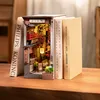 A 3D wooden book nook depicting a Japanese alleyway, placed between two books on a wooden surface. Voir les images du produit