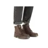 A person wearing dark jeans and brown leather boots. Produktbild-Vorschau
