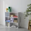 A white bookshelf with various items on its shelves, placed against a white wall. Produktbild-Vorschau