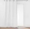 A white curtain hangs in front of a glass door, with a dark curtain rod above. Produktbild-Vorschau
