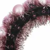 A close-up view of a festive headband decorated with pink baubles and tinsel. Voir les images du produit