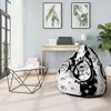 A modern living room with a bean bag chair, desk, and artwork. Voir les images du produit