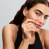 A woman wearing a black top, showing off a ring on her finger. Produktbild-Vorschau