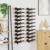 Two black metal wine racks mounted on a white wall, each holding multiple wine bottles. A wooden shelf unit with books and plants is to the left. A wooden cabinet with decorative items is to the right. Produktbild-Vorschau