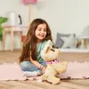 A young girl is sitting on the floor playing with a stuffed dog. Anteprima dell’immagine prodotto