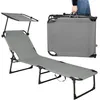 A gray foldable sun lounger with a canopy is shown, with a folded version of the lounger being carried by a person in the background. Anteprima dell’immagine prodotto
