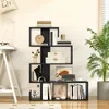 A modern living room scene with a black S-shaped bookshelf filled with books and decorative items. Podgląd zdjęcia produktu